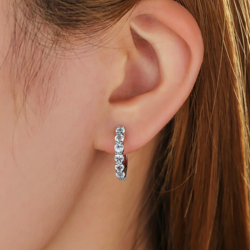 Blue Topaz huggie hoop earrings, Sterling Silver, worn on ear
